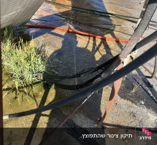 צל של דוד שמש על הקרקע עם צינורות מים